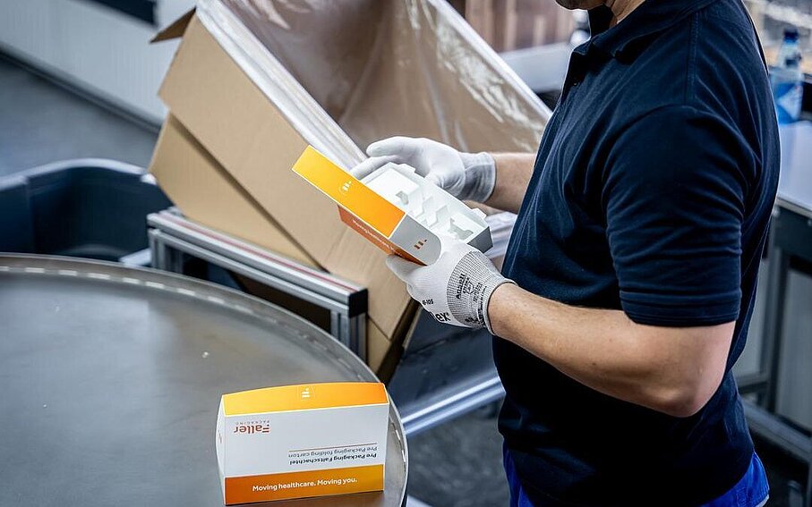 Mitarbeiter prüft vorkonfektionierte pharmazeutische Faltschachtel im PrePackaging Service von Faller Packaging