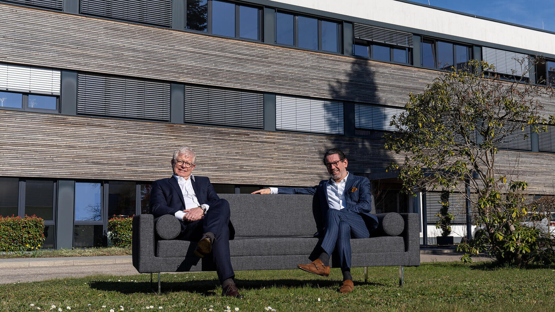 Faller Packaging management sitting in the green in front of the headquarters in Waldkirch
