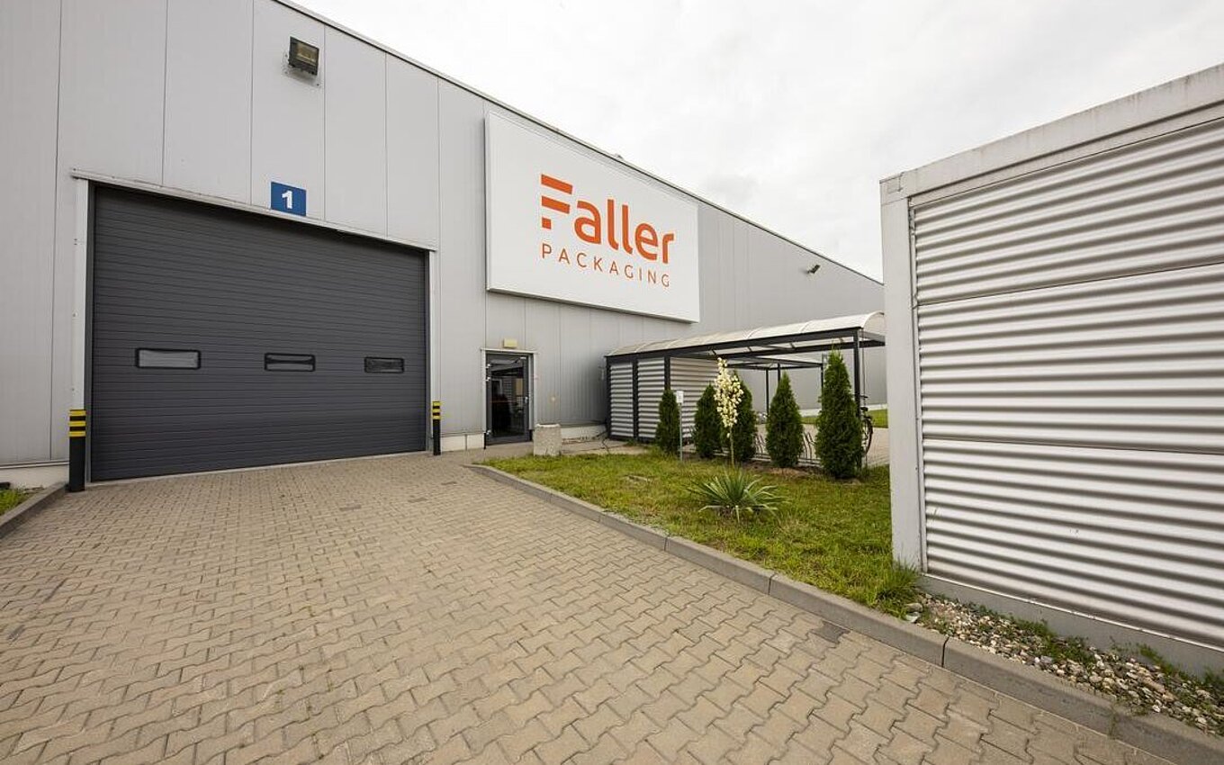 Gebäude des Faller Packaging Standorts in Łódź, Polen – Außenansicht mit Werkseingang und Firmenlogo, neben den Informationen zu Adresse und Warenannahmezeiten.
